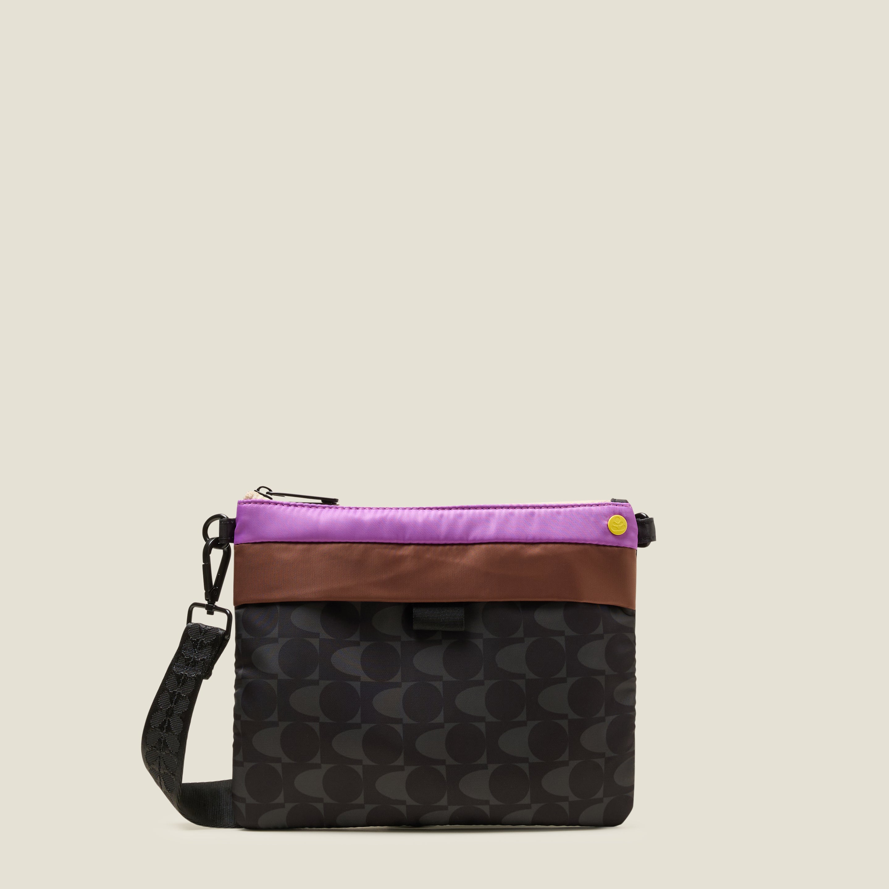 Multicoloured women's bag with a grey and black pattern with contrast purple and brown top on a beige background