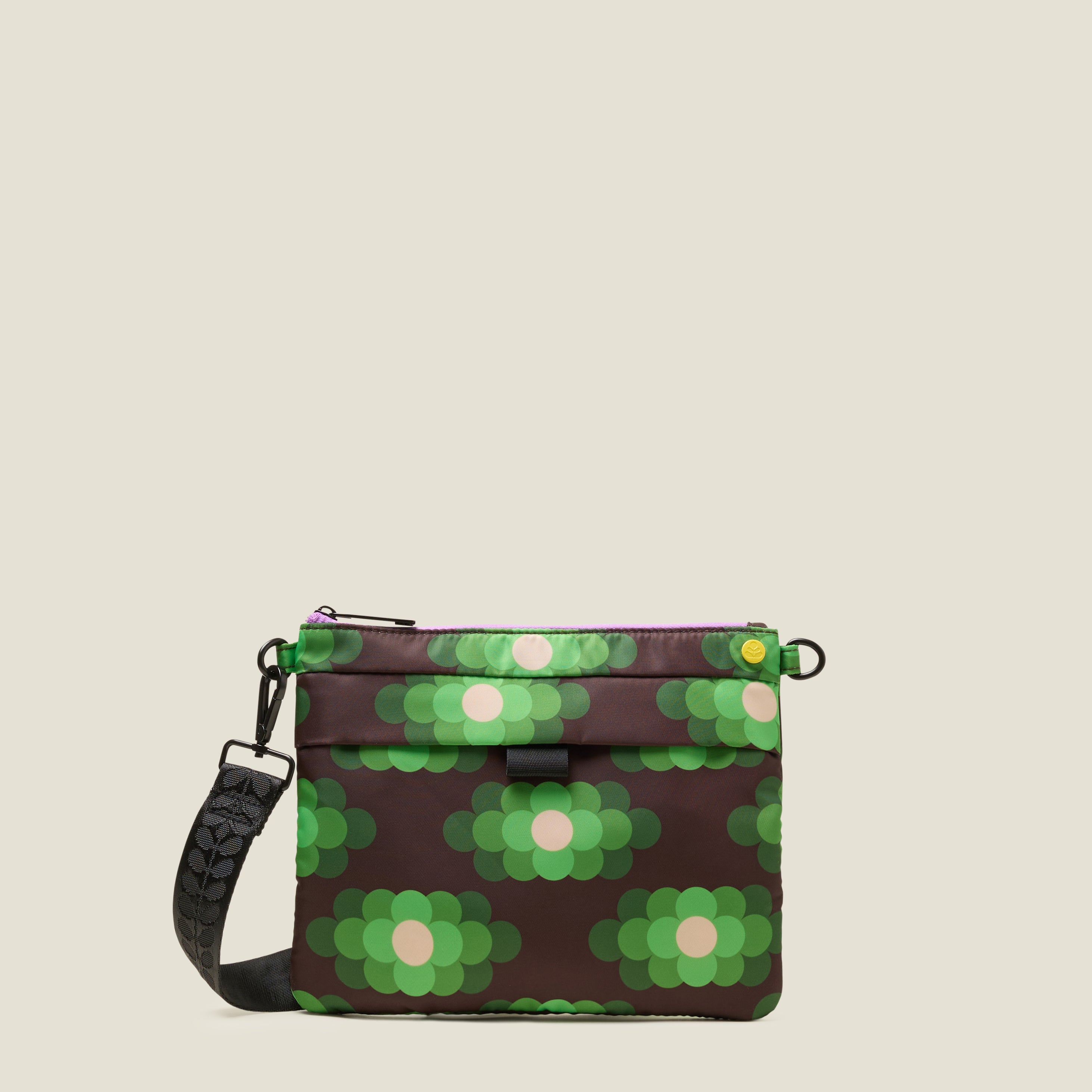 Green, brown and cream floral patterned crossbody bag on a beige background