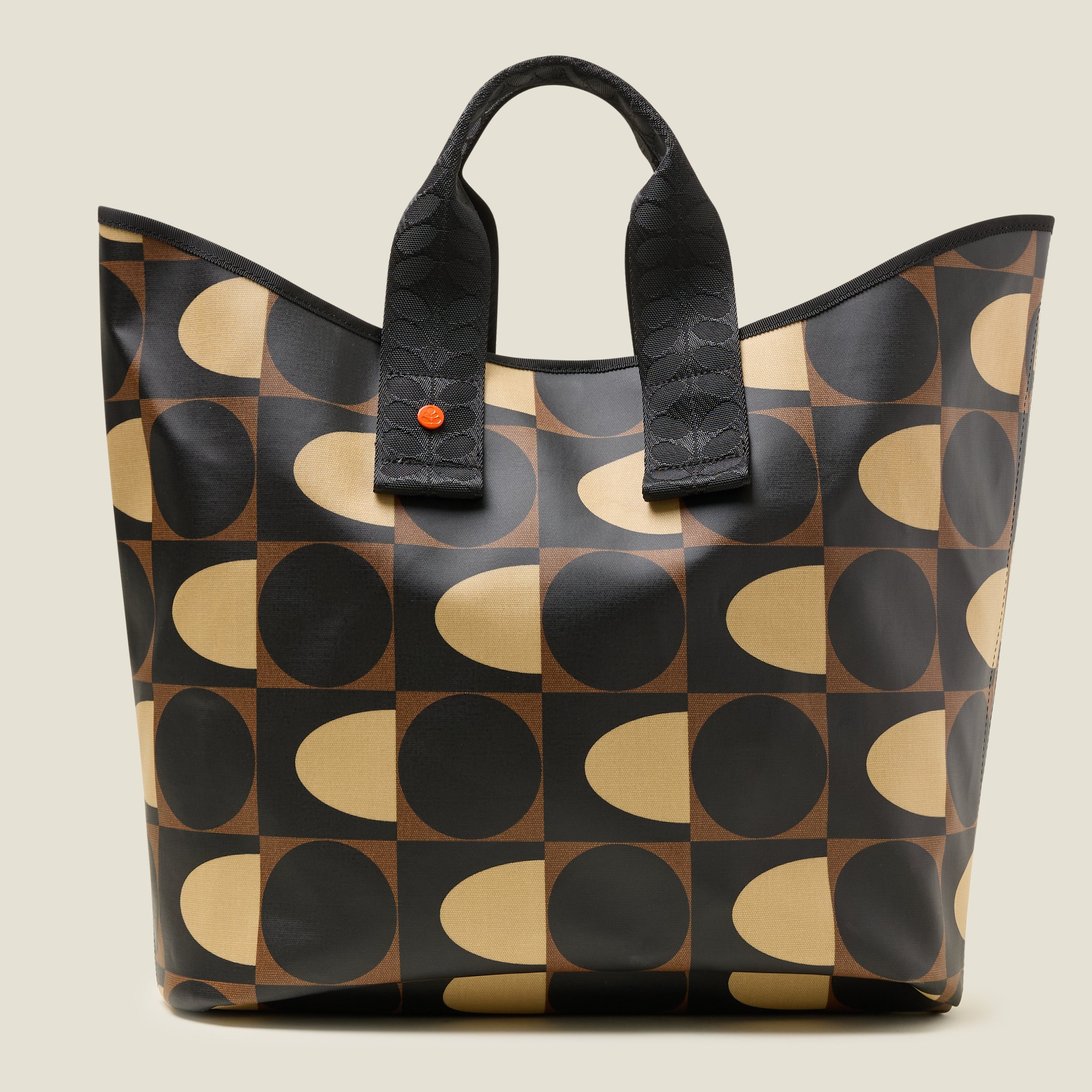 Front view of patterned tote bag with black, brown and beige spot square printed design. Two short grab handles