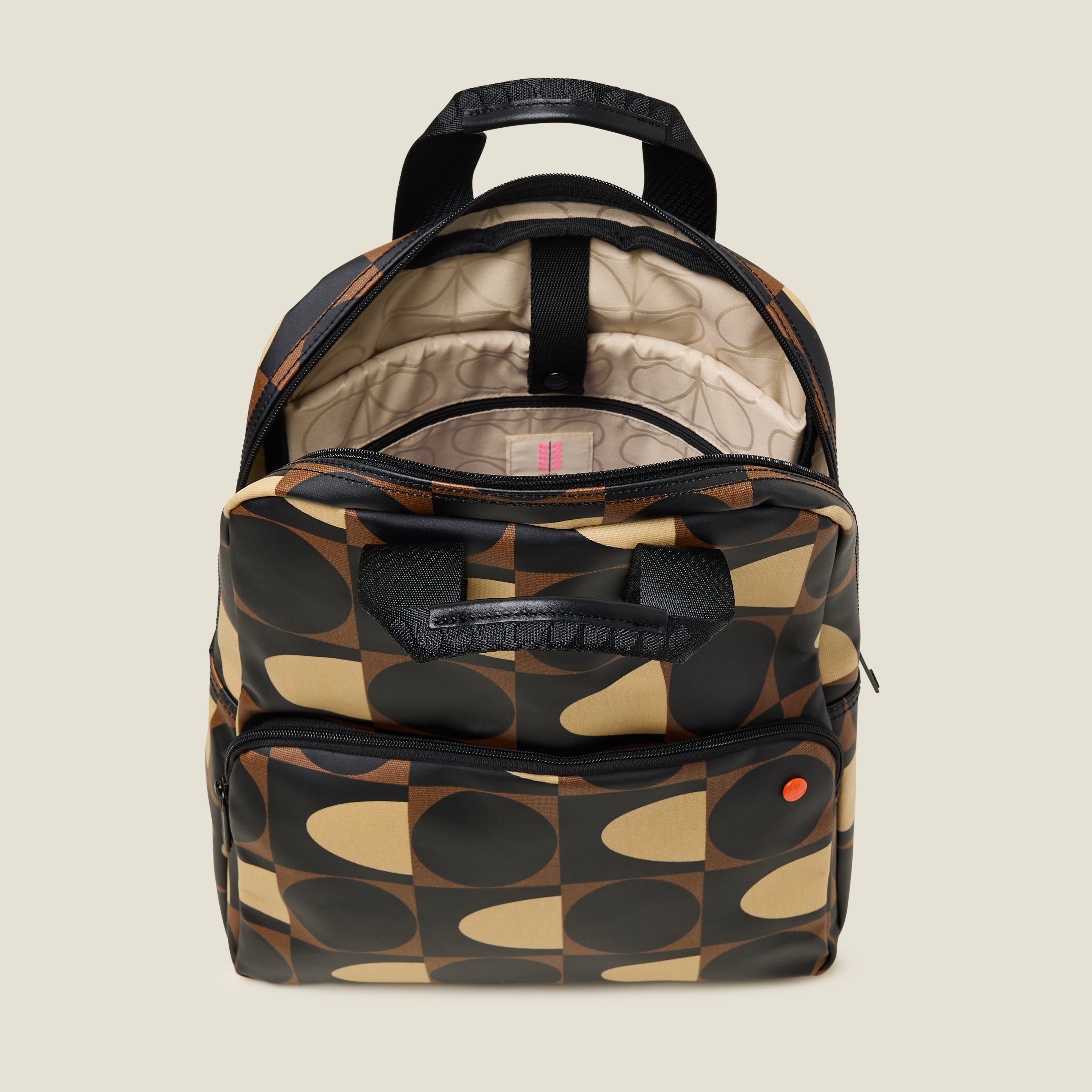 Inside view of the Lotta Backpack in a brown and cream print featuring a padded laptop sleeve and beige lining.