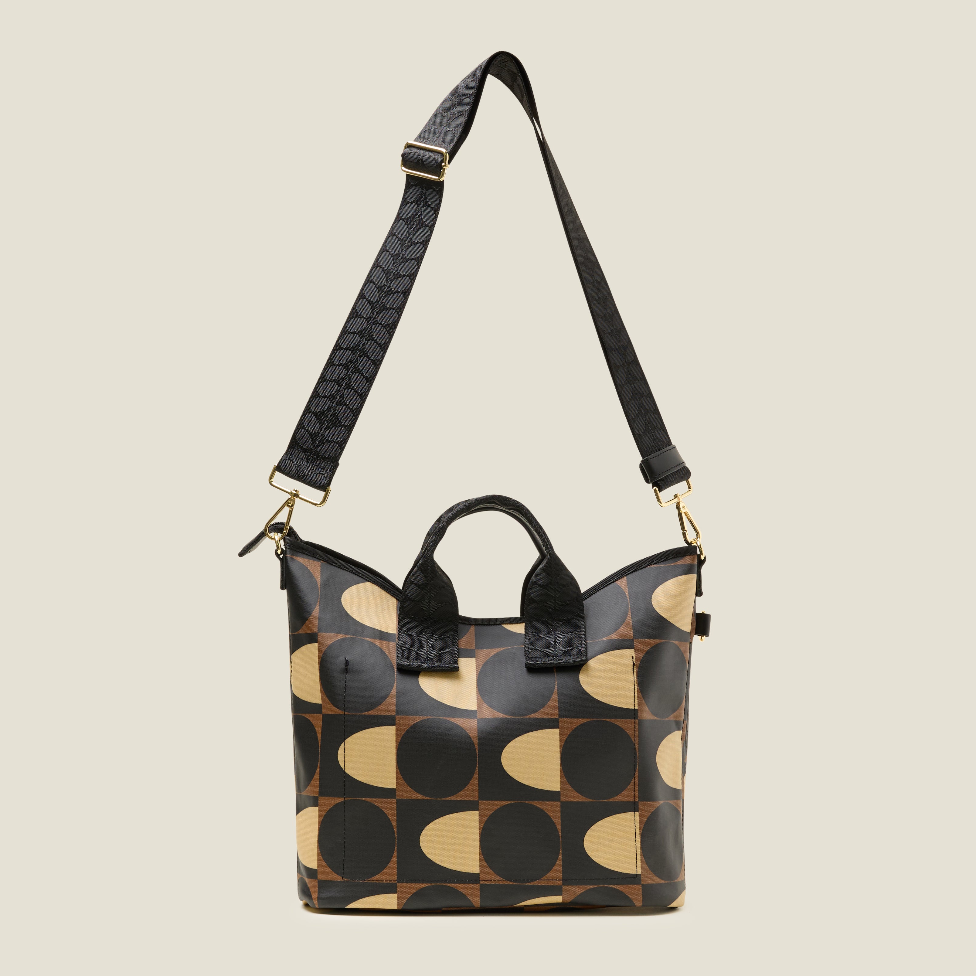Back view of a patterned handbag, with slip pocket with geometric mocha brown print design with crossbody strap at full length